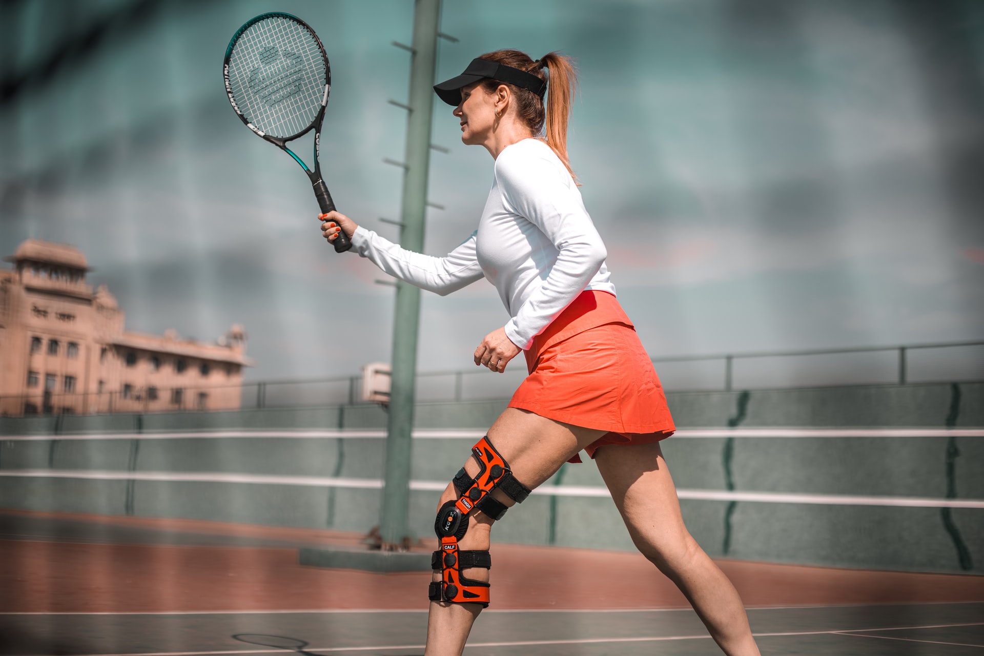 Vrouw die tennis speelt met knie brace